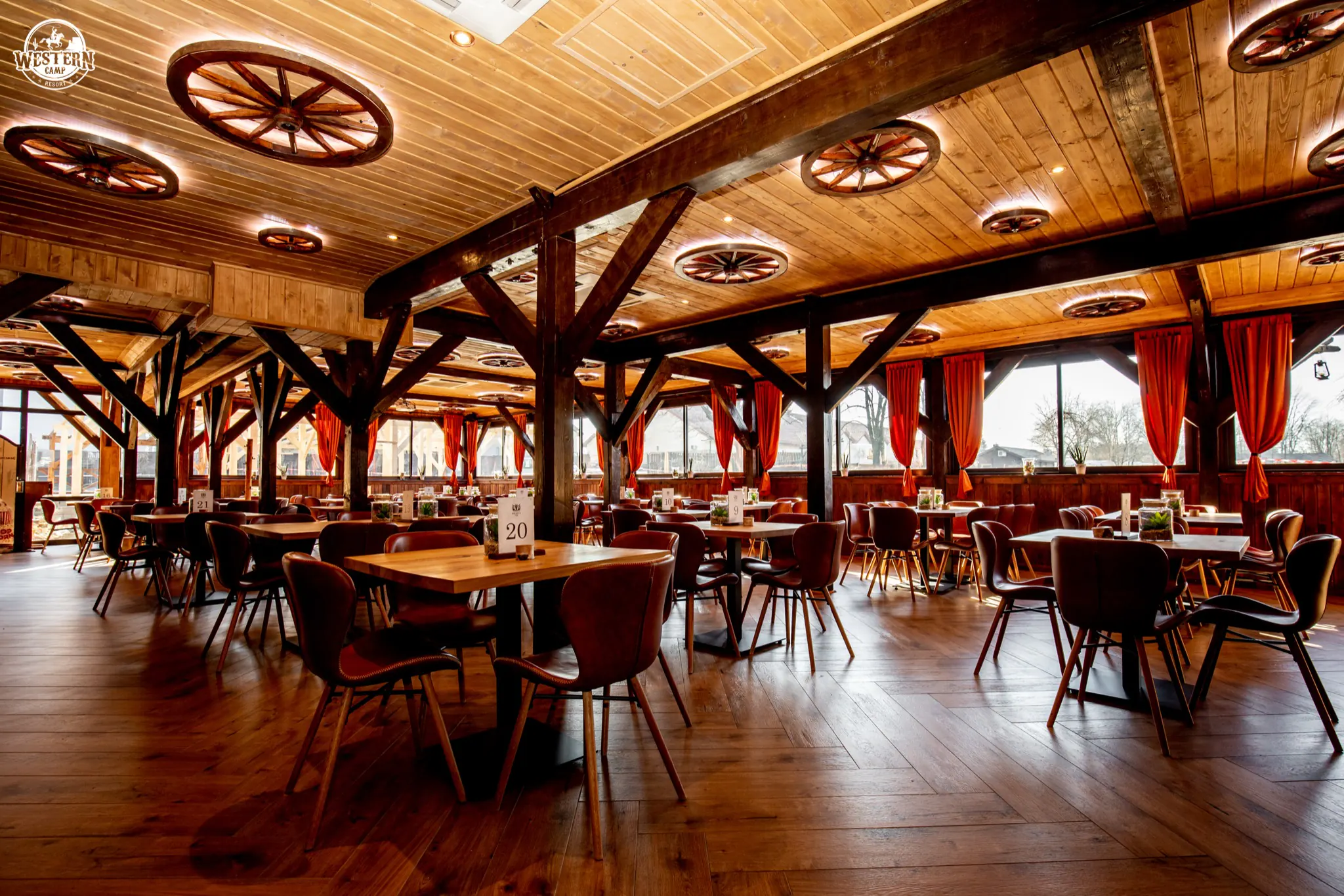 Sala Restauracji Colorado: drewniane belki, koła wozów pod sufitem i czerwone zasłony